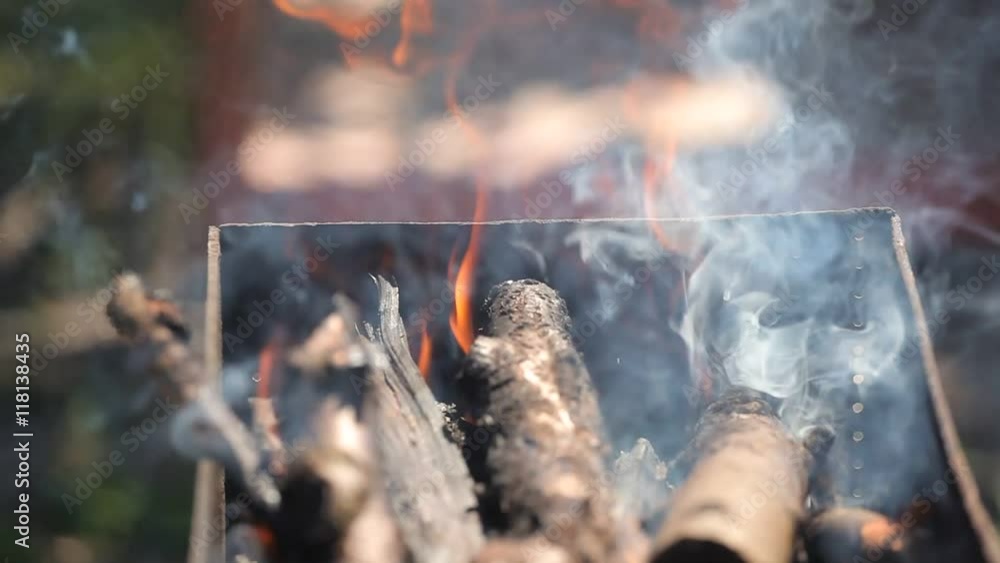 branches of cherry wood stacked in a barbecue burning bright red flames branches of cherry wood stacked in a barbecue burning bright red flames