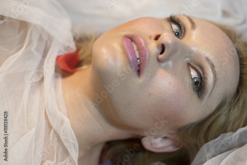 Vintage  Sensual blonde lying with white gauze and red flower pe