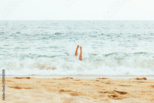 Woman jumping in the wave on the beautiful beach