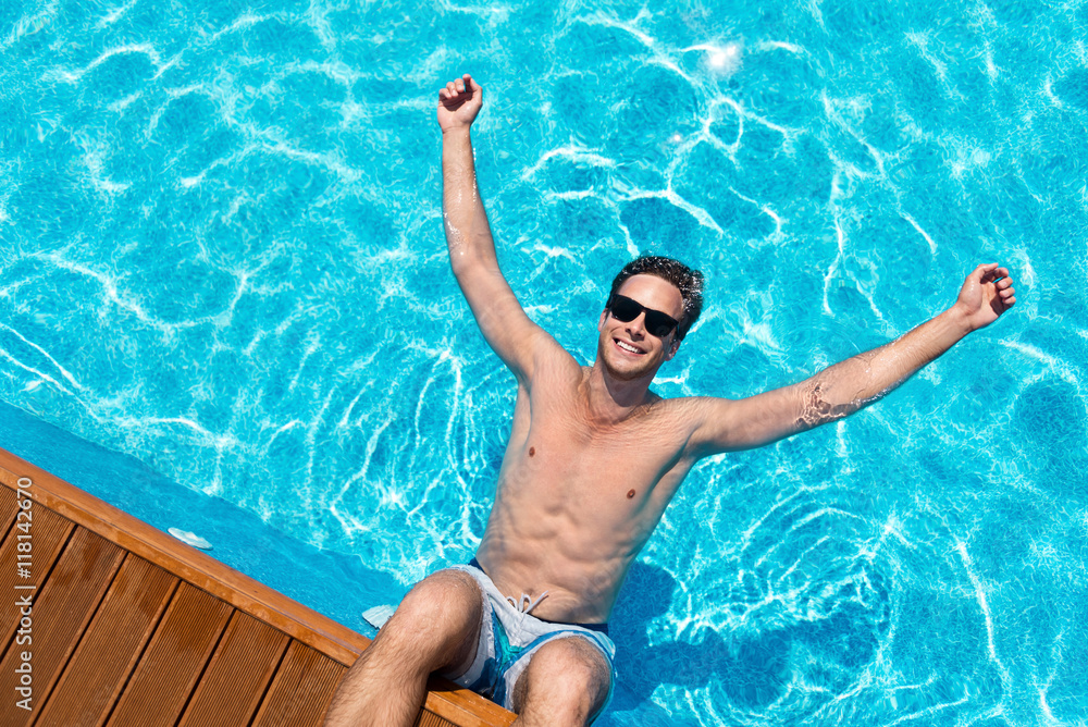 Cheerful man resting in the swimming pool