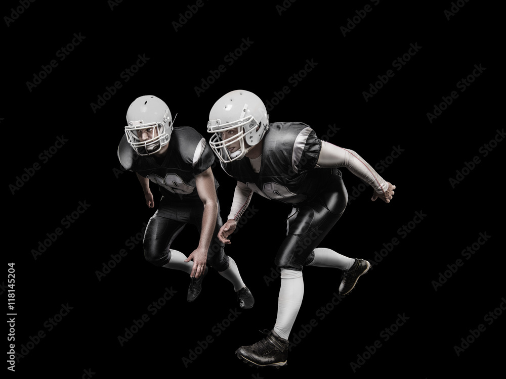 American football players in a grey uniform on black background