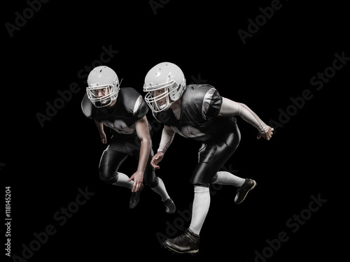 American football players in a grey uniform on black background
