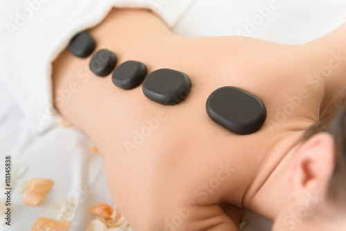 Young girl getting stones massage at spa