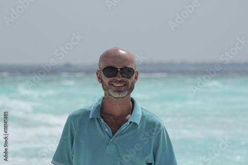 hairless middle-aged man on the beach