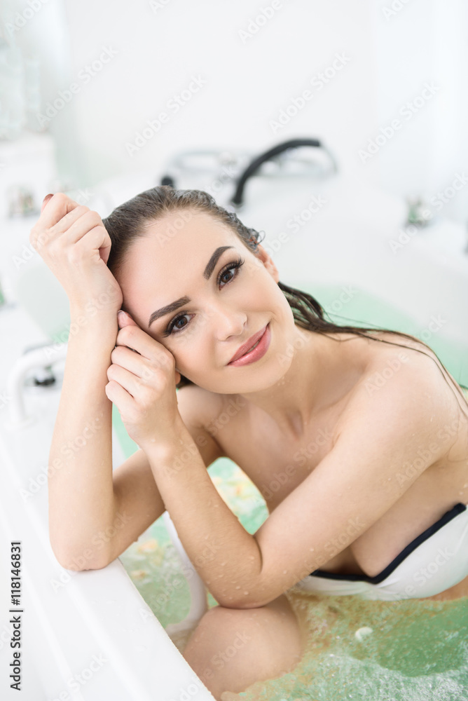 Joyful girl resting in whirlpool bath Joyful girl resting in whirlpool bath