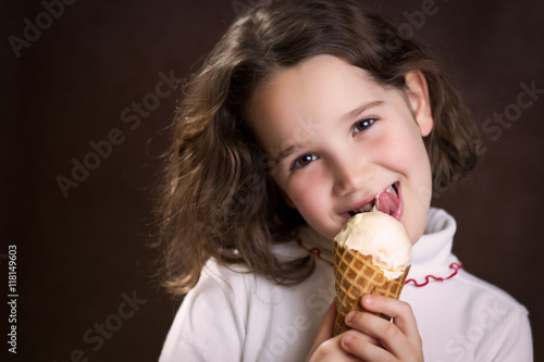 Foto Girl holding and licking ice cream cone