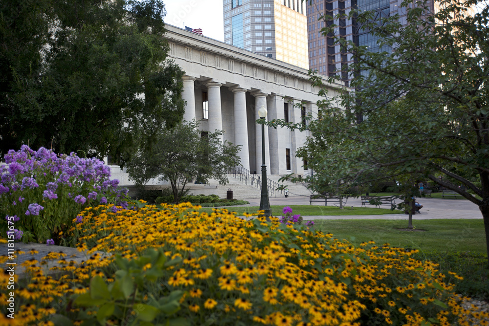 The northern facade of the Ohio Statehouse is flanked by colorful flowers.