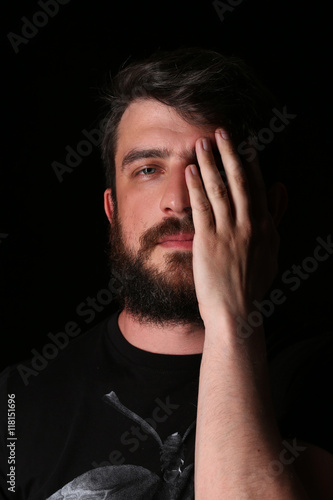 Portrait of bearded man with hand on his face. Close.up. Black