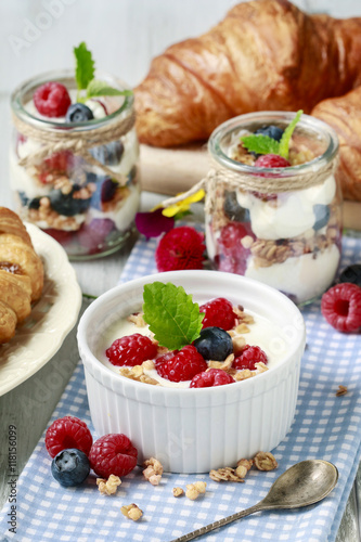 Breakfast table: bowl of yogurt with muesli and fresh fruits