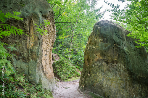 Rocks with a broken-down cross them at the gates of the monastery in the cave in the Carpathian foothills Rozhirche