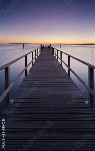Wooden Pier into a Lake at Sunset, perfect symmetry