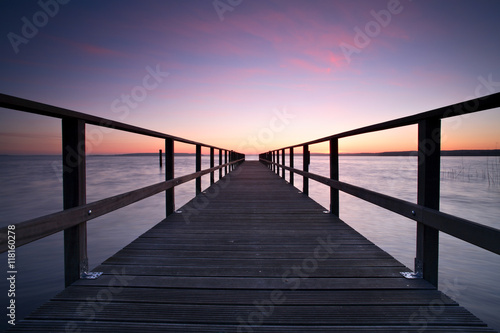 Long Wooden Pier into a Lake at Sunset  perfect symmetry