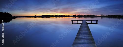 Wooden Pier into a Calm Lake at Sunset