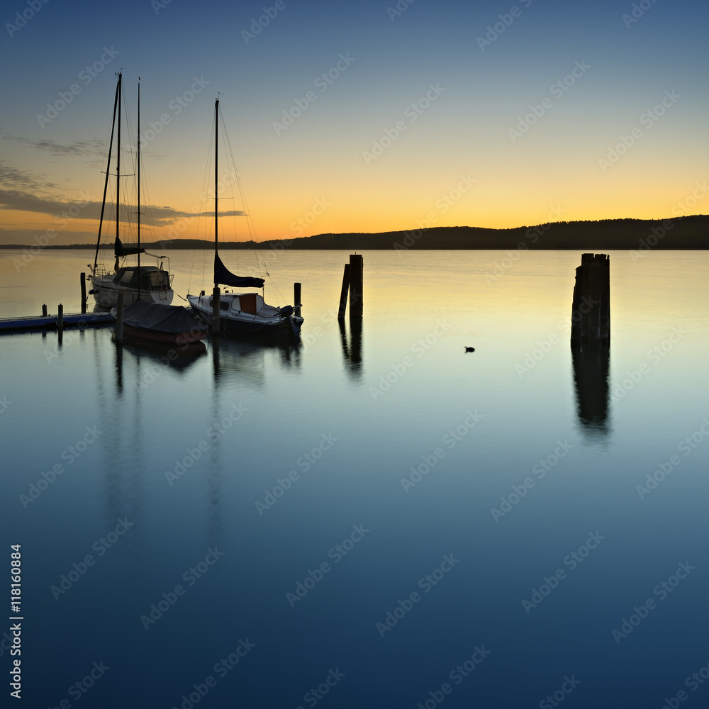 Sailing Boat Tied to Small Pier on Lake at Sunrise Sailing Boat Tied to Small Pier on Lake at Sunrise
