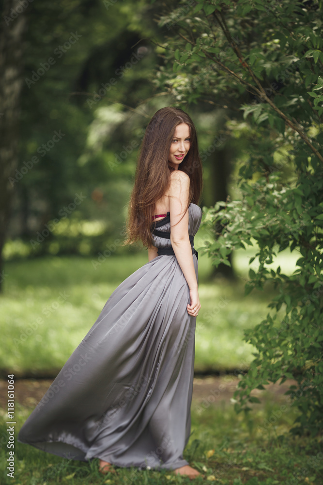 Beauty Romantic Girl Outdoors. Teenage Model with Casual Dress in park. Blowing Long Hair. Beauty Romantic Girl Outdoors. Teenage Model with Casual Dress in park. Blowing Long Hair.