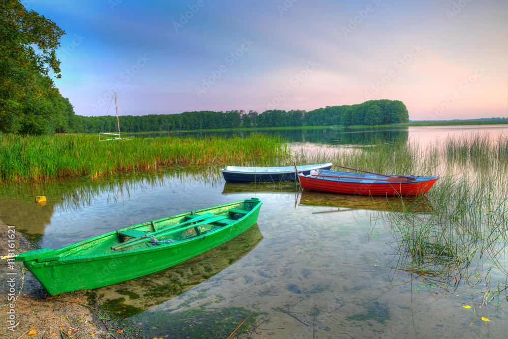 Rowing boats floating over the Lake Lasmiady waters early morning. HDR image. Masuria, Poland.
