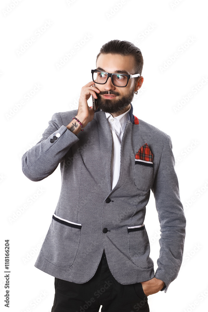 Stylish guy with glasses talking on the phone on a white backgro Stylish guy with glasses talking on the phone on a white backgro