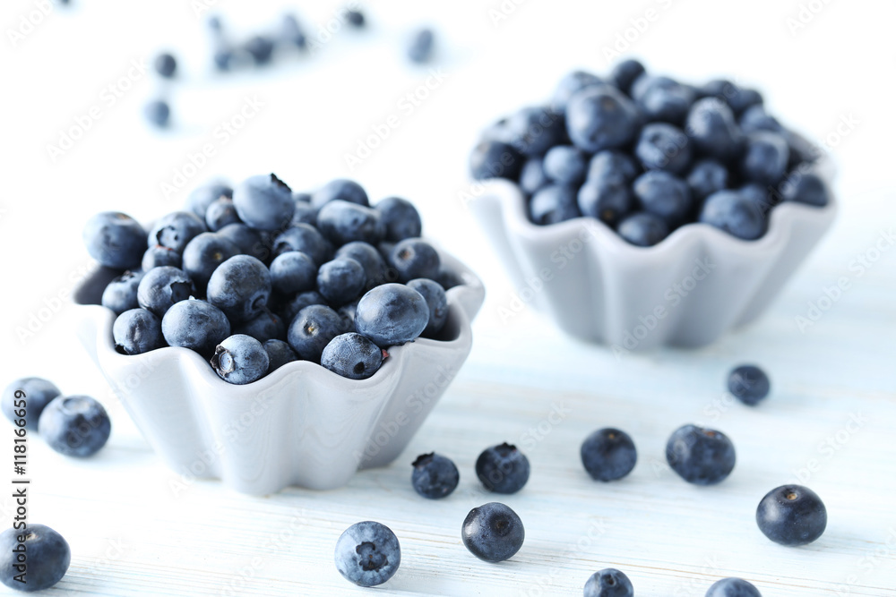 Ripe and tasty blueberries on blue wooden table Ripe and tasty blueberries on blue wooden table
