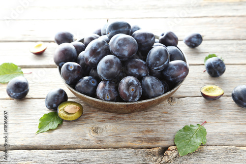 Tasty and ripe plums on grey wooden table