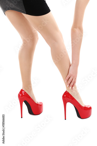 Female legs with red high heels on a white background