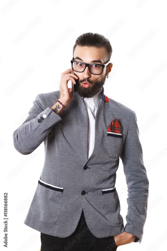 Stylish guy with glasses talking on the phone on a white backgro Stylish guy with glasses talking on the phone on a white backgro