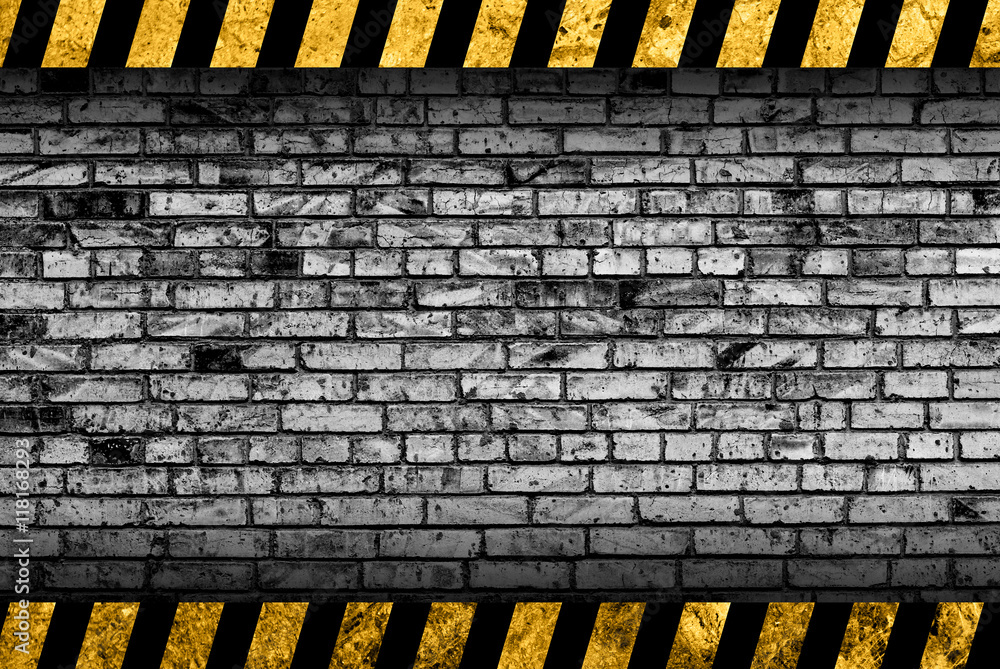 Grunge grey brick wall background with black and yellow warning stripes ...