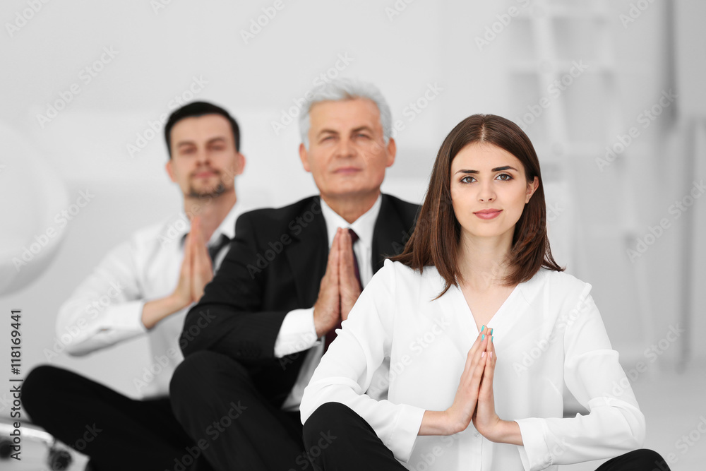 Business people relaxing in meditation pose in office Business people relaxing in meditation pose in office