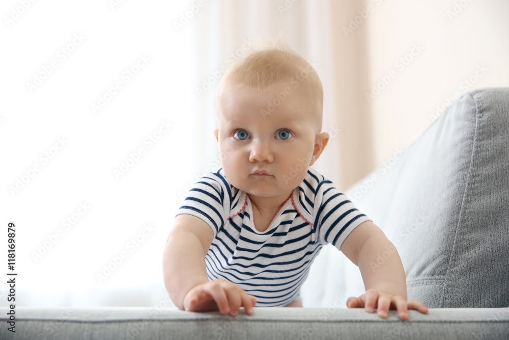 Adorable little baby crawling on light sofa Adorable little baby crawling on light sofa