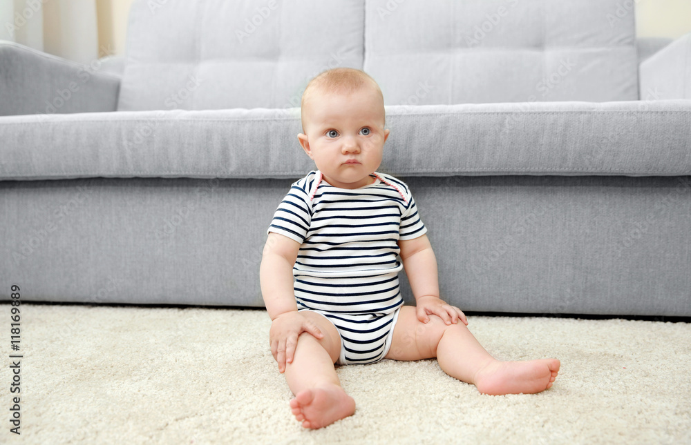 Adorable little baby sitting on light carpet Adorable little baby sitting on light carpet