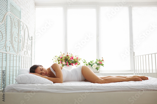 Sexy slim woman in white underwear sleeping on bed with white sh