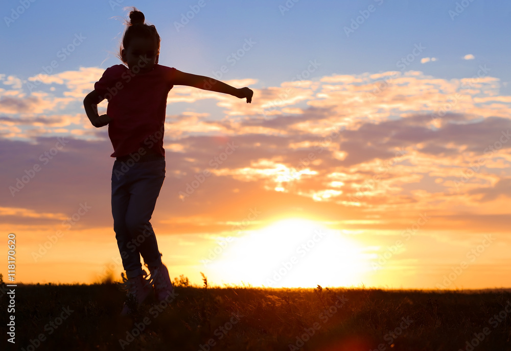 Cute girl silhouette on sunset background