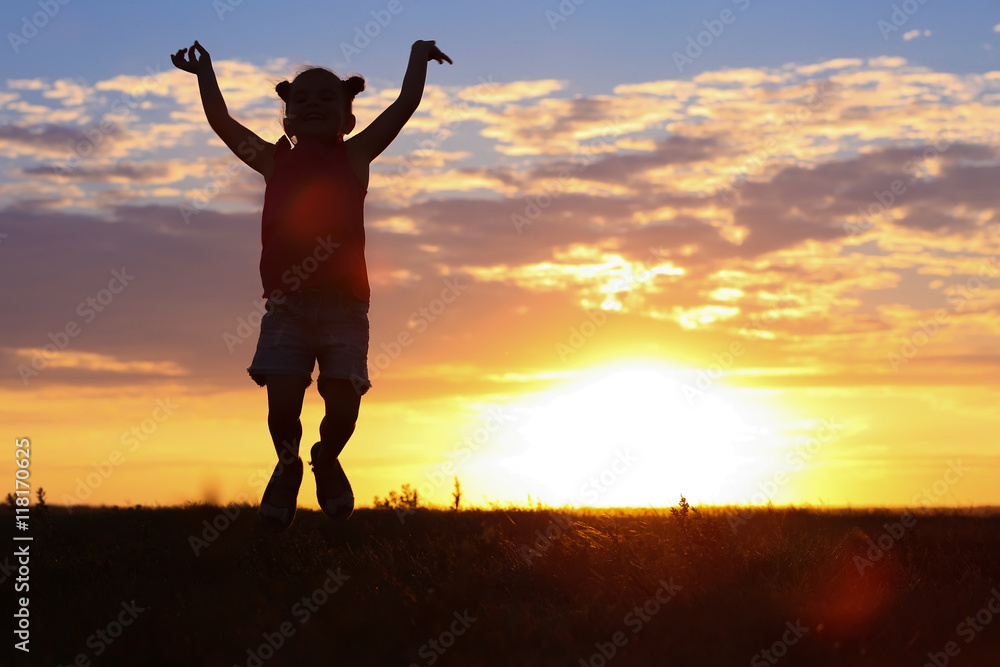 Cute girl silhouette on sunset background