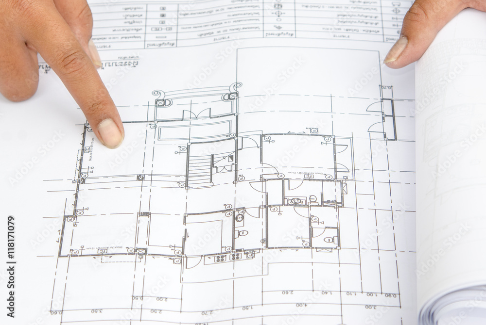 Hands of architects working on blueprints in the office, selective focus Hands of architects working on blueprints in the office, selective focus
