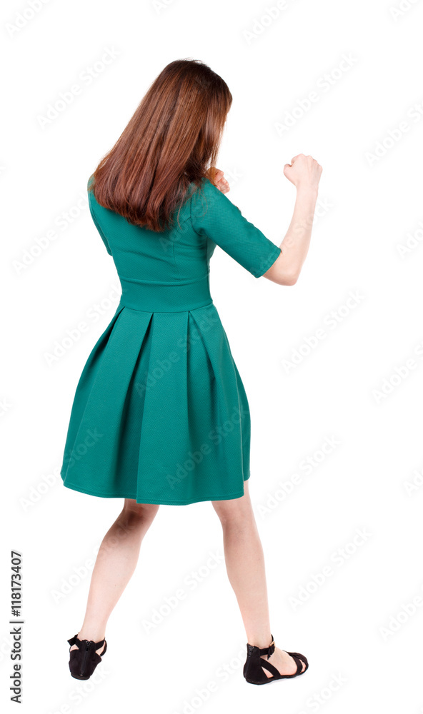 skinny woman funny fights waving his arms and legs. Isolated over white background. The slender brunette in a green short dress has her hands. skinny woman funny fights waving his arms and legs. Isolated over white background. The slender brunette in a green short dress has her hands.