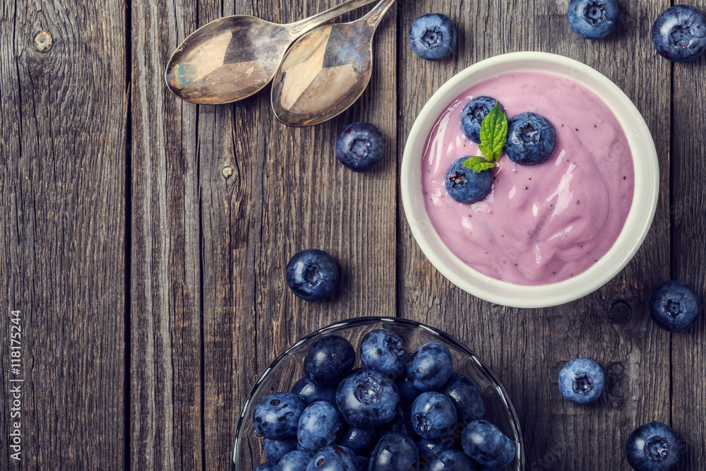Homemade yogurt with fresh blueberry on a wooden background. Homemade yogurt with fresh blueberry on a wooden background.
