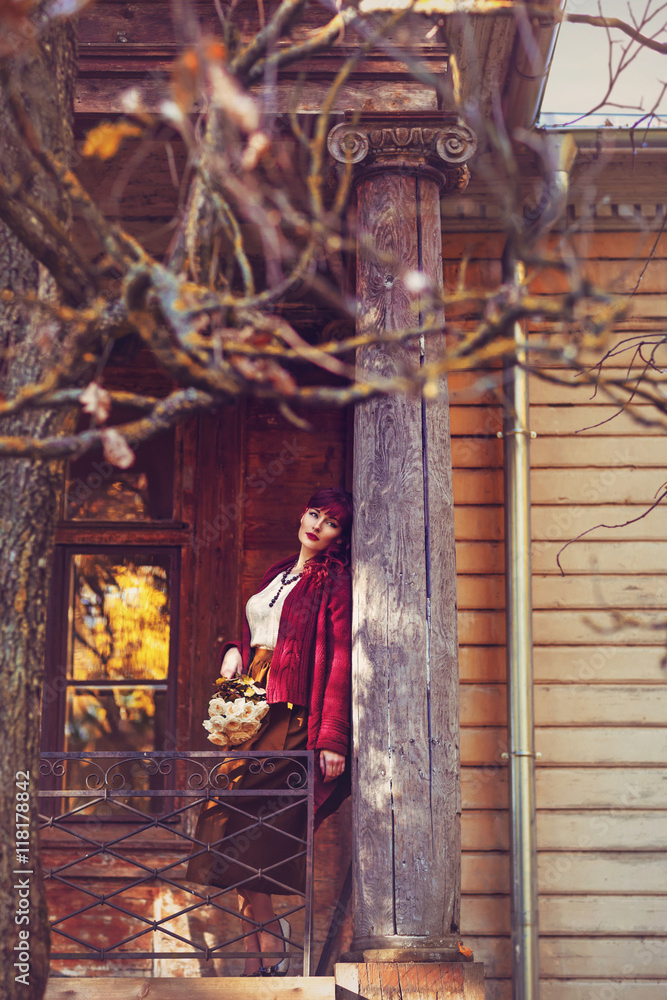 Girl standing on old house balcony