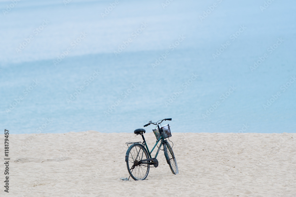 Fototapeta premium Bicycle with Basket parked on the sandy beach.