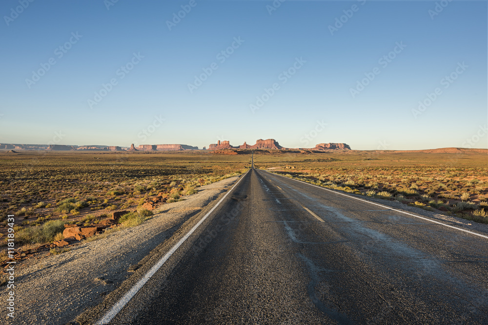 View of Monument Valley canyons during sunrise with Road in Arizona View of Monument Valley canyons during sunrise with Road in Arizona