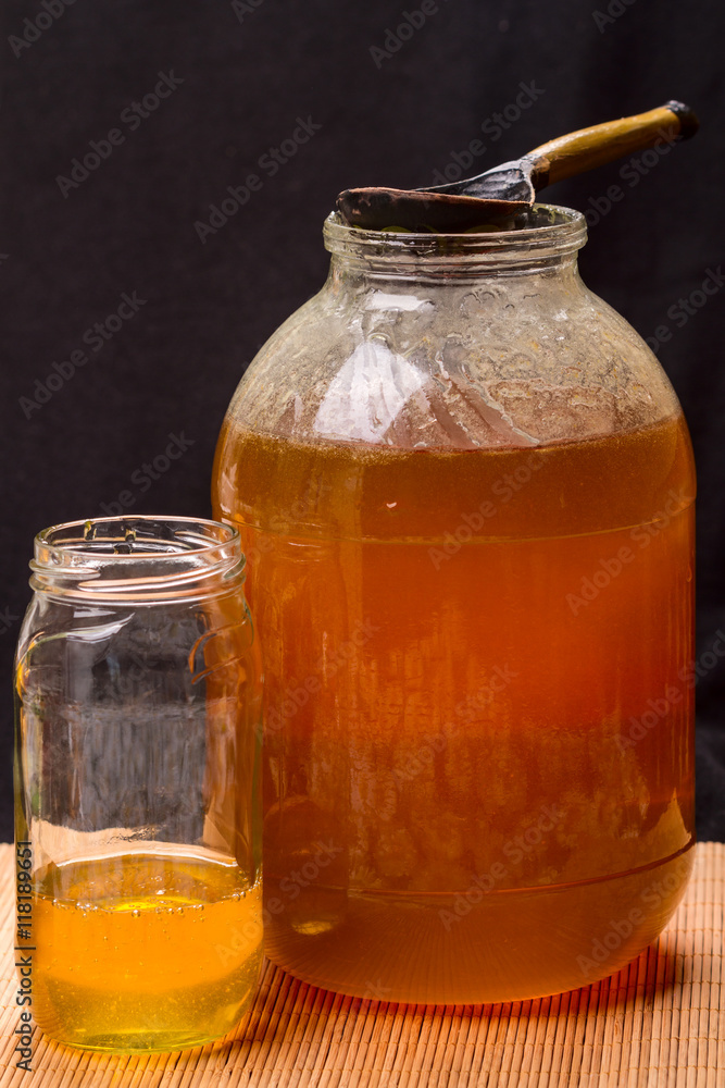 Large jar with honey and wooden spoon Large jar with honey and wooden spoon