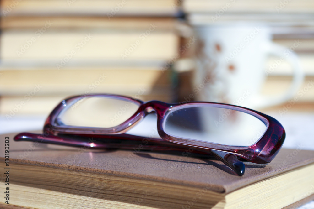 Book and glasses ,Cup of coffee in the background. Education is the path to knowledge and education. The wisdom and concepts of the study. Book and glasses ,Cup of coffee in the background. Education is the path to knowledge and education. The wisdom and concepts of the study.
