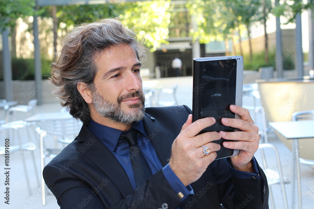 Businessman using electronic tab outside congress center Businessman using electronic tab outside congress center