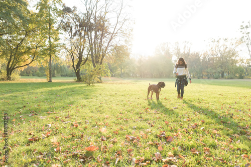 Beautiful young woman playing with her Dog in the forest