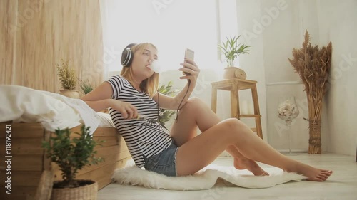 vaping girl in headphones smoking at home