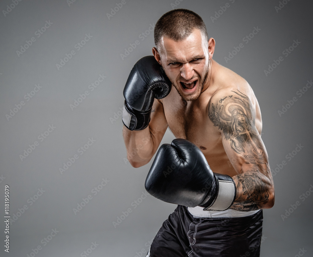 Tattooed fighter isolated on a grey background. Tattooed fighter isolated on a grey background.