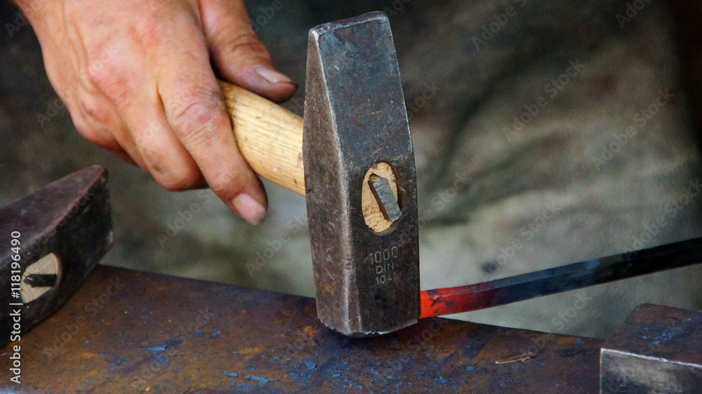 Schmied bearbeitet mit dem Hammer glühenden Stahl auf dem Amboss (Nahaufnahme) Schmied bearbeitet mit dem Hammer glühenden Stahl auf dem Amboss (Nahaufnahme)