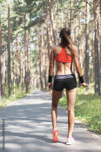 Young woman warming up before starting running outdoors