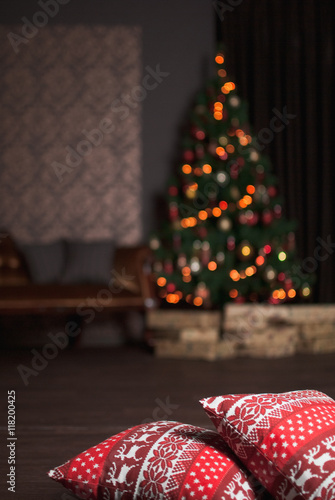Christmas interior with pillows, gift, tree and garland