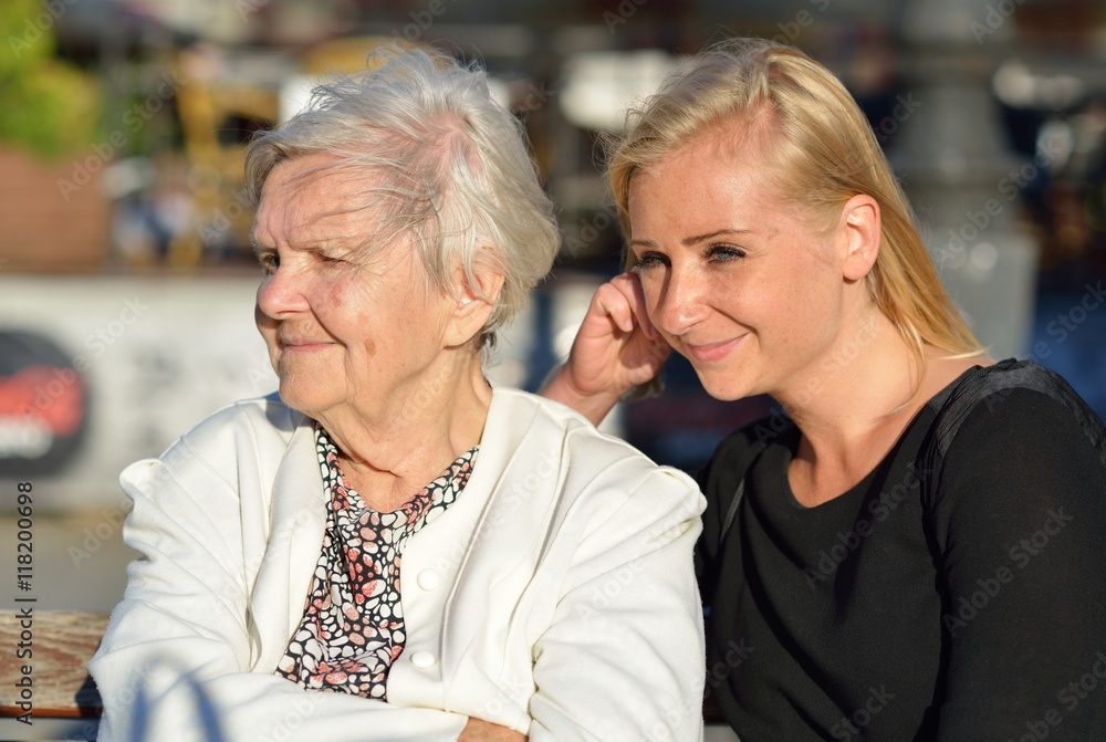 Grandmother and granddaughter. Young woman carefully takes care