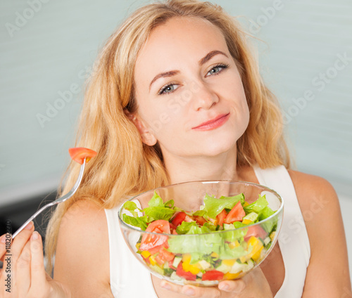 Young woman eating vegetable salad