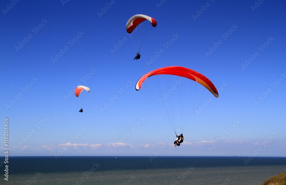 Gleitschirmflieger am Meer vor blauen Himmel Gleitschirmflieger am Meer vor blauen Himmel